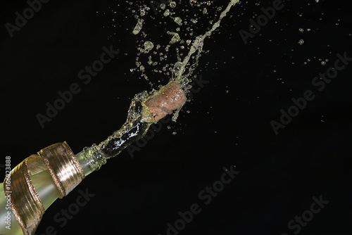 Corkscrew out of a bottle of champagne on a black background