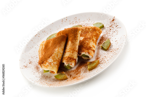 Crepes with kiwi and cream on white background 