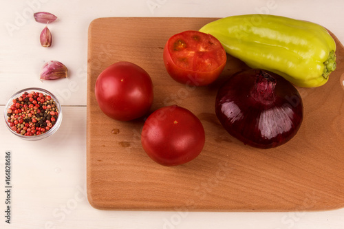 Vegetables on a cutting board closeup -  bell pepper, tomatoes, red onion