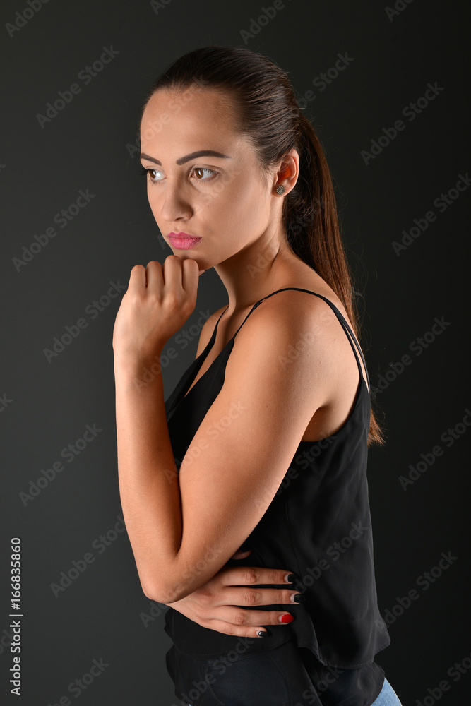 Fototapeta premium Beautiful woman posing in studio on dark background