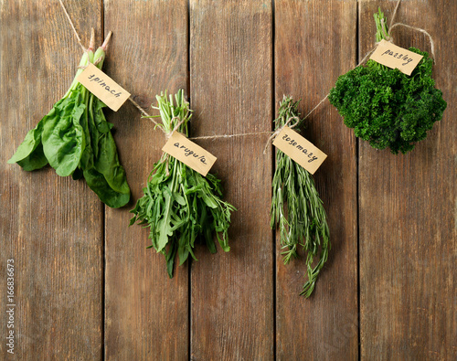 Fresh herbs hanging on wooden background