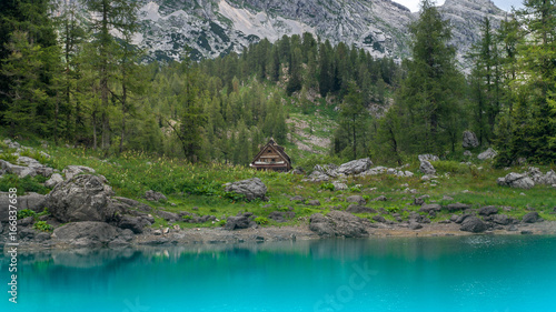 Panoramic view of the mountain hut in Triglav Lakes Valley with green forest and high mountains in the background.Julian Alps, Slovenia.