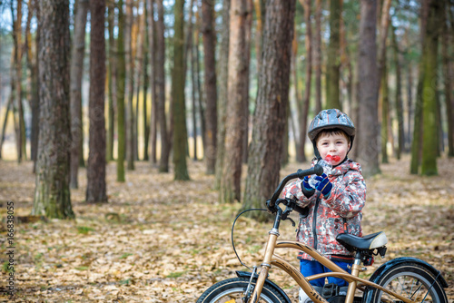 Young boy with bicycle with drinking clear water