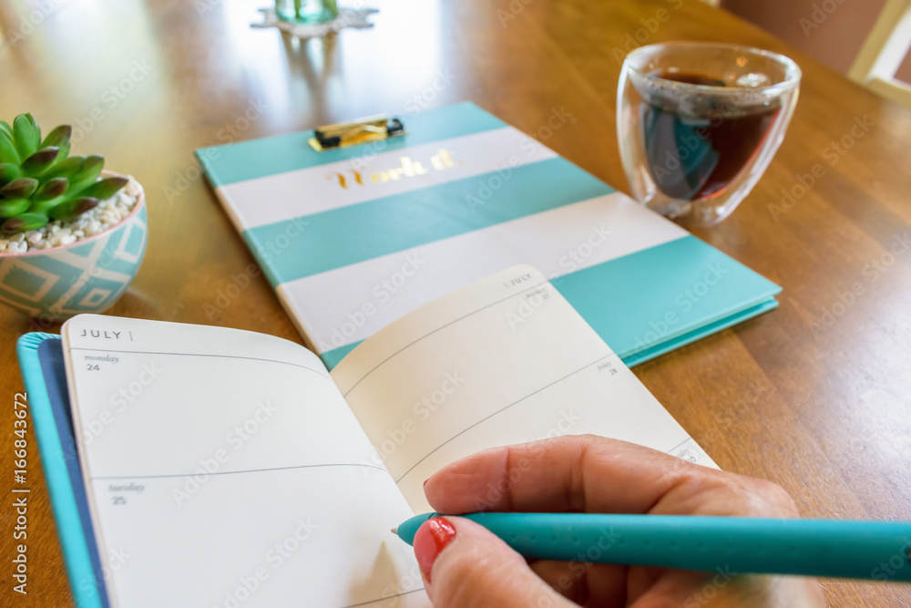 Keeping track of appointments by writing in a weekly planner Keeping track of appointments by writing in a weekly planner