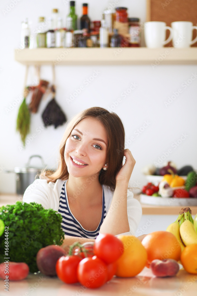 Young woman standing near desk in the kitchen Young woman standing near desk in the kitchen