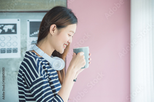 Beautisul asian woman drinking coffee in office and smile photo