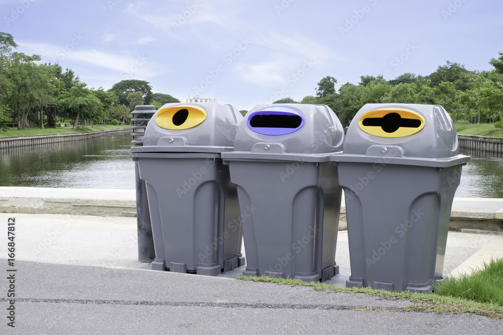 Foto de Segregated waste bins for garbage in public park. Recycle bin do Stock Adobe Stock