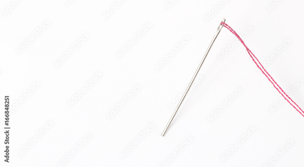 Sewing needle with red thread through the white background Sewing needle with red thread through the white background