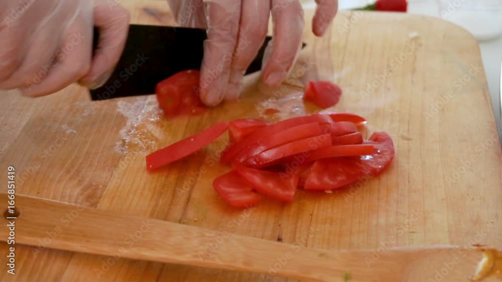 Cutting tomato on wooden board, closeup
Cutting tomato on wooden board, closeup