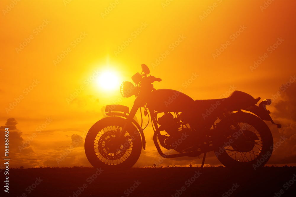 Fototapeta premium Silhouette of motorbike beside the natural lake and beautiful,sunset background and sky.