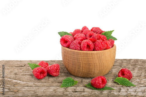 Raspberry in a wooden bowl on table with white background