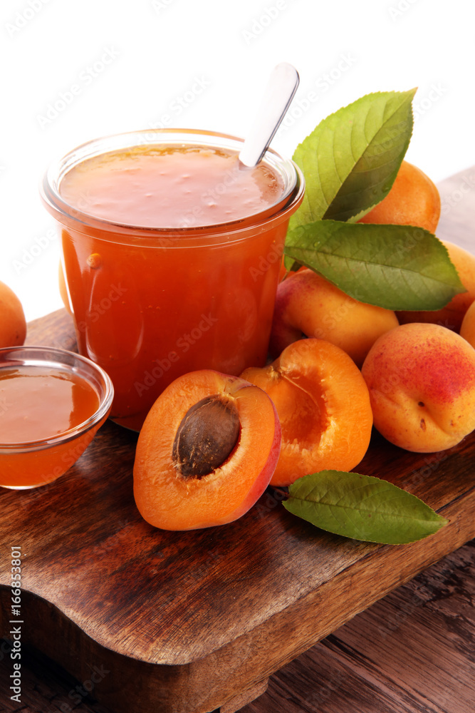 Apricot jam in glass bowl with fruit around Apricot jam in glass bowl with fruit around