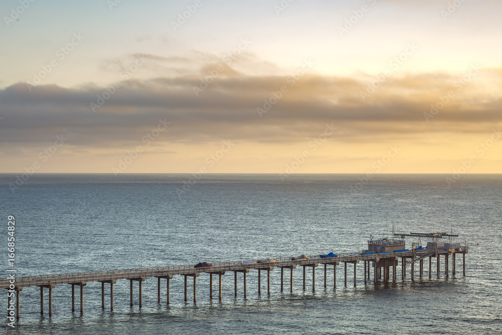 The Scripps pier and sunset on the horizon in California