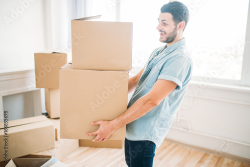 Man holds carton box in hands, housewarming © Nomad_Soul