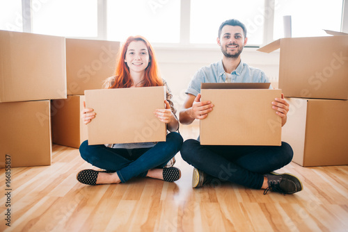 Couple with cardboard boxes in hands, new home