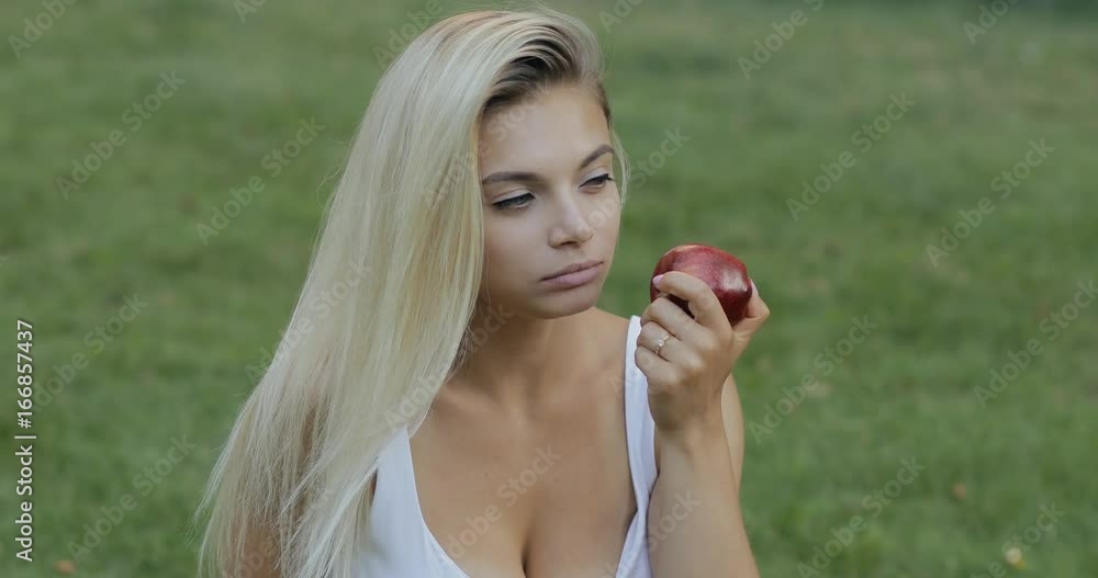 Pretty woman eating apple outdoors, healthy food concept Pretty woman eating apple outdoors, healthy food concept