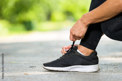 runner woman tie shoe  in a park