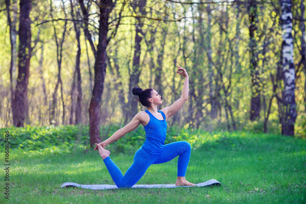 Young woman doing yoga exercises in the summer city park. Health lifestyle concept. Young woman doing yoga exercises in the summer city park. Health lifestyle concept.