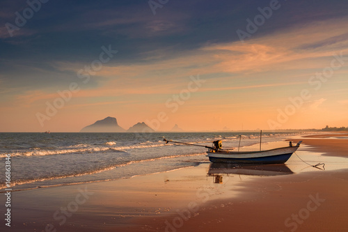 On the beach with colorful sunset, boat, sea and montian in Prachuab Kiri Khan, Thailand. 