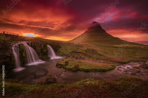 Colorful midnight sunset at Kirjufell in summer with a view mountain, waterfall and cloudy sky of 