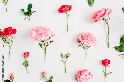 Floral pattern made of pink and red roses, green leaves, branches on white background. Flat lay, top view. Valentine's background. Floral background. Pattern of flowers.