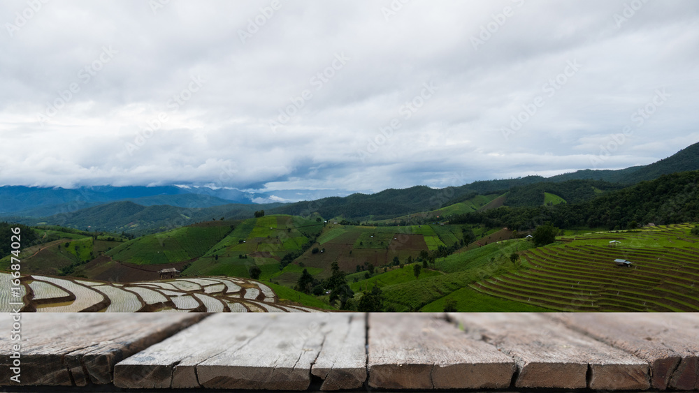 green rice field on terrace in mountain valley. beautiful nature landscape in rainy season. agriculture industry with wood table for display your product green rice field on terrace in mountain valley. beautiful nature landscape in rainy season. agriculture industry with wood table for display your product