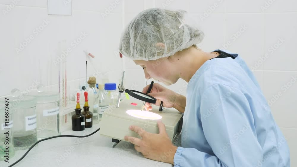 A woman in the laboratory is engaged in research, counting using special equipment A woman in the laboratory is engaged in research, counting using special equipment