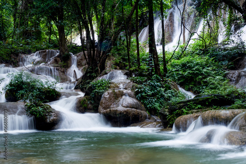 Teal and clear water of the Phatad Waterfall in Kanchanaburi, Thailand. 