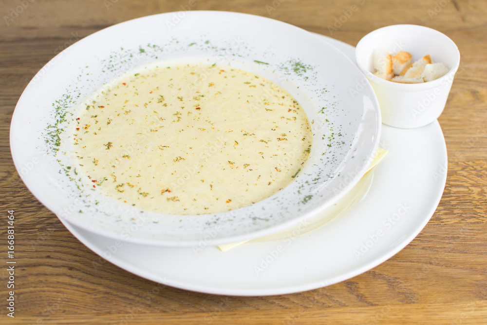 Tomato soup in a black bowl on wooden table. Top view. Tomato soup in a black bowl on wooden table. Top view.