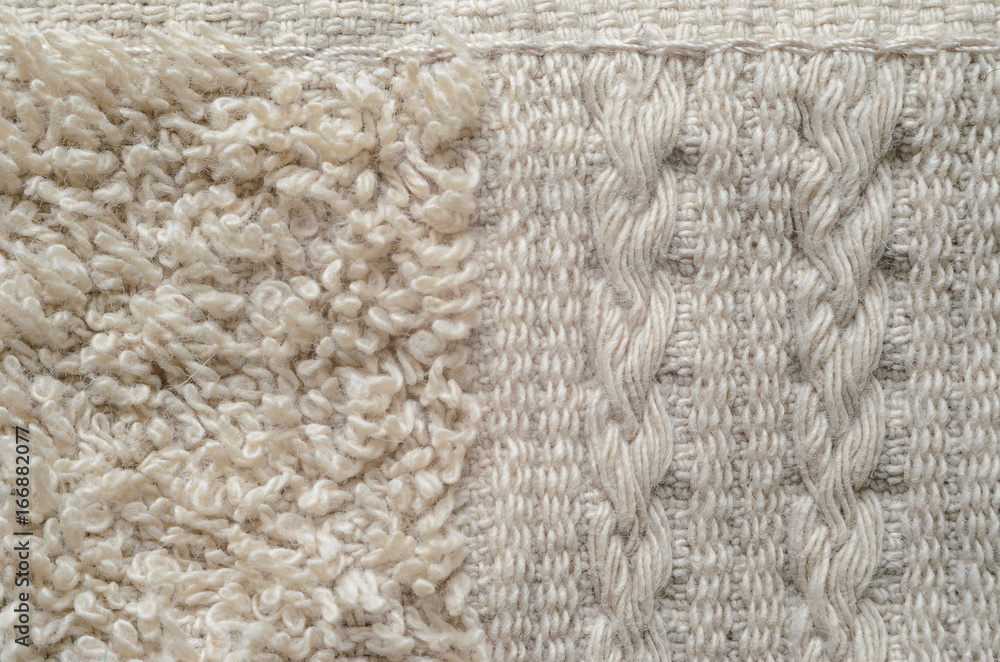 A macro shot of an element of beige color towel. Fleecy part and decorative element with braided pigtails. Texture is similar to the texture of a fleecy knotted-pile carpet. A macro shot of an element of beige color towel. Fleecy part and decorative element with braided pigtails. Texture is similar to the texture of a fleecy knotted-pile carpet.