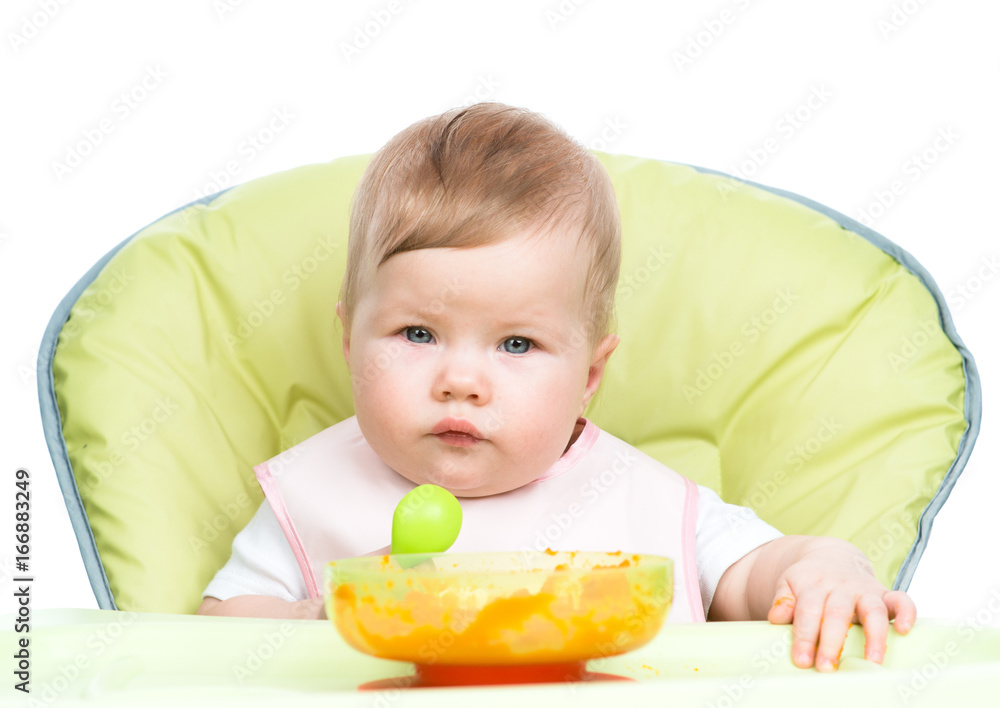 Baby sitting in high-chair with spoon and plate. isolated on white background Baby sitting in high-chair with spoon and plate. isolated on white background