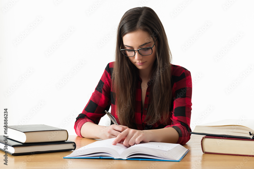 Attractive caucasian girl studying for her exams at home, education concept on white background Attractive caucasian girl studying for her exams at home, education concept on white background