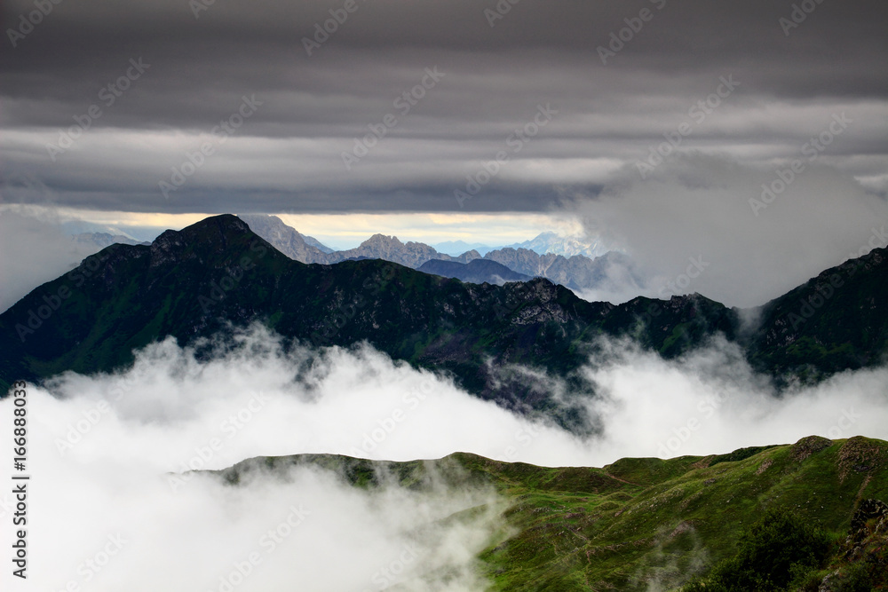 Two-thousanders of Carnic Alps, Cimone di Crasulina and Monte Sernio peaks, in the clouds with Julian Alps in the background, Friuli Venezia Giulia region, Northern Italy, Europe