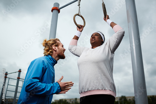 Canvas Print Personal trainer motivating chubby client