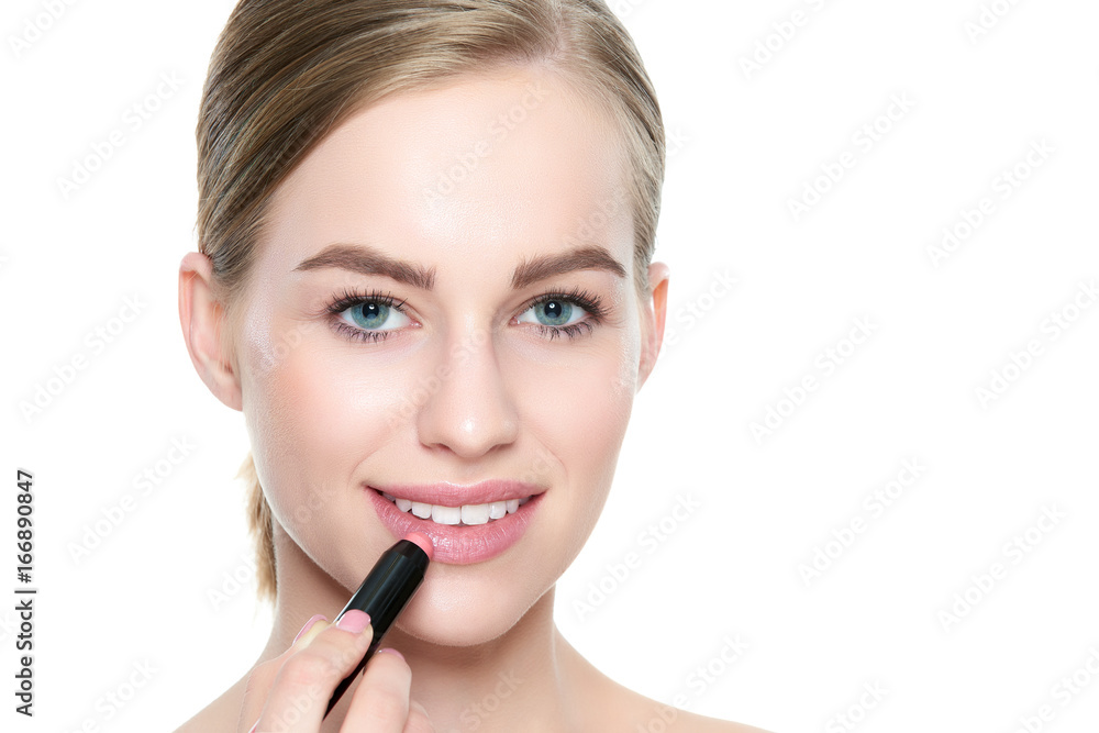 Beautiful young blond woman with sexy full lips applying coral color lipstick. Beauty portrait isolated over white background with copy space. Beautiful young blond woman with sexy full lips applying coral color lipstick. Beauty portrait isolated over white background with copy space.