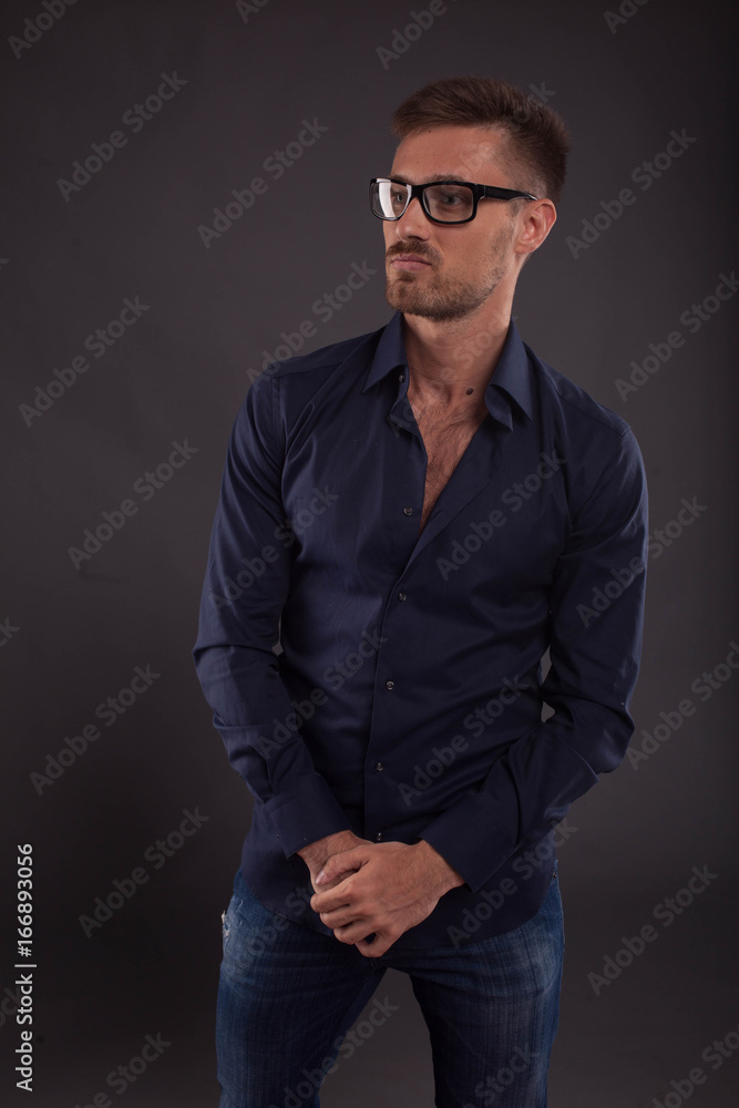 Young confident man portrait of a confident businessman showing by hands on a black background. Ideal for banners, registration forms, presentation, landings, presenting concept. Young confident man portrait of a confident businessman showing by hands on a black background. Ideal for banners, registration forms, presentation, landings, presenting concept.