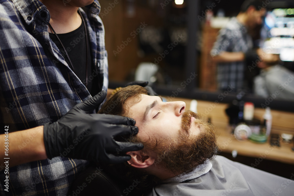 Obraz premium Beautician taking care of client face during massage procedure