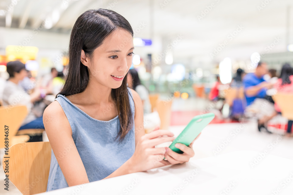 Woman using mobile phone in restaurant