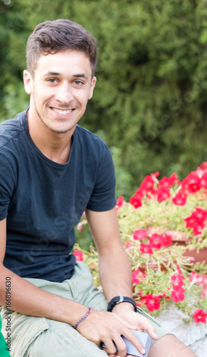 portrait of happy young man sitting in the garden