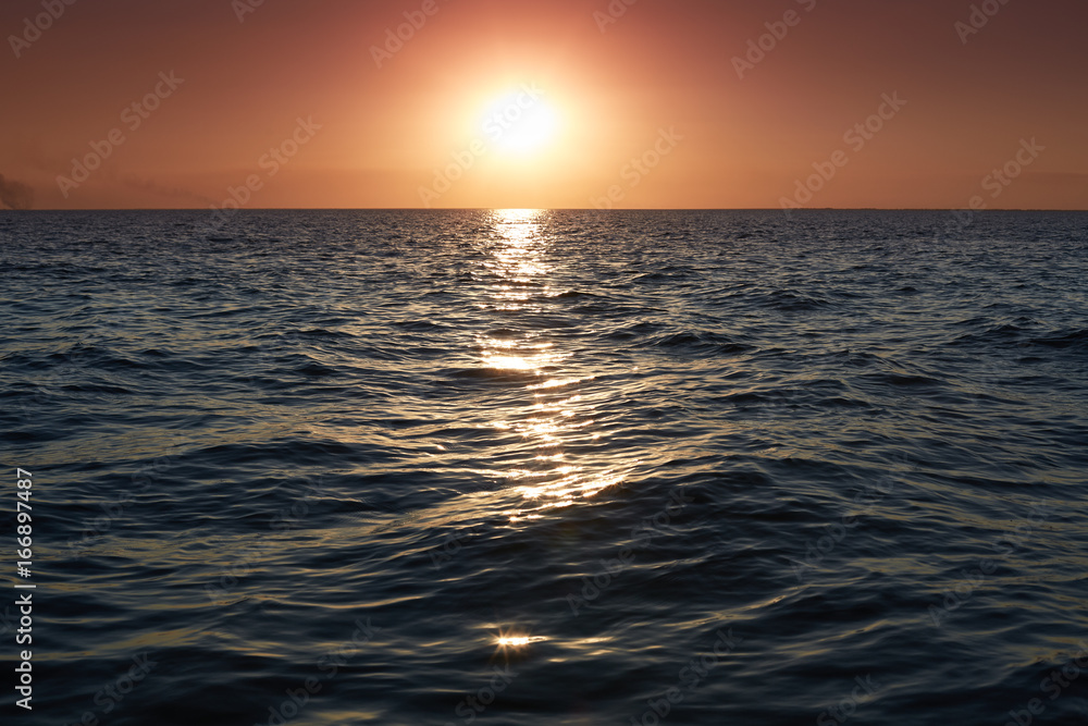 Panorama of beautiful sunset on sea. Bright horizon landscape over water. Dramatic sunset with twilight color sky and waves of sea. Calm atmosphere. Beautiful nature background. Evening charming sea