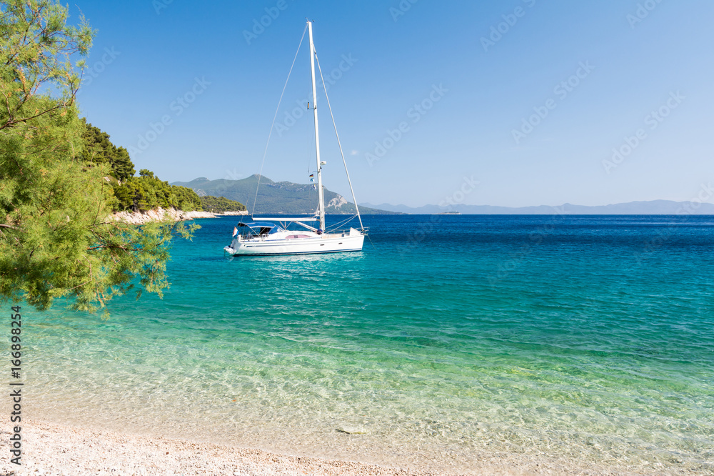 Obraz premium piękna plaża z jachtem na dalmatyńskiej wyspie, Dalmacja, Chorwacja
