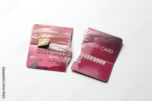 Closeup of the broken red credit card on the white background.