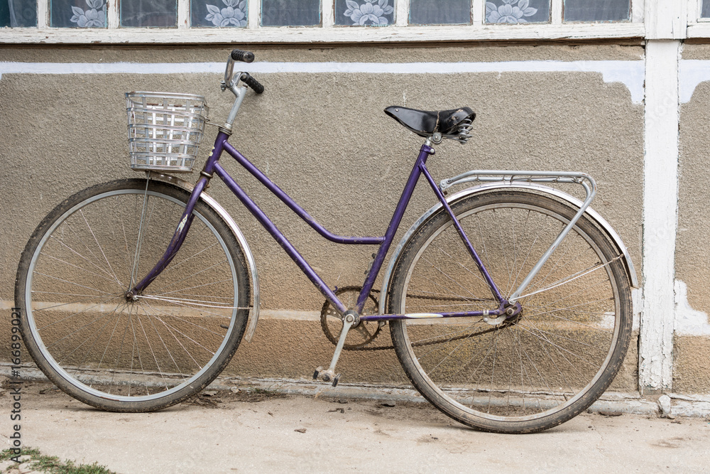 Bicycle with a basket in the courtyard of a rural house
