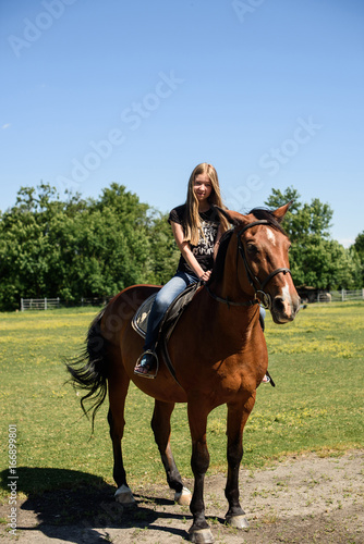 young beautiful brunette girl riding horse outdoor