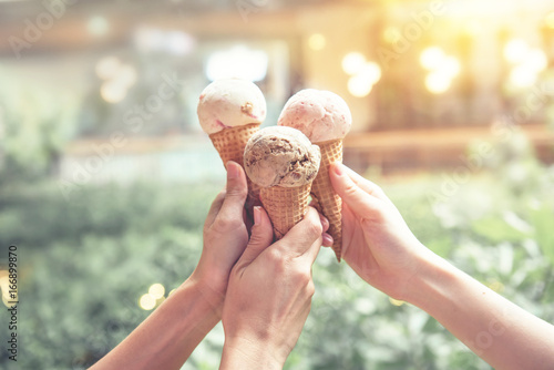 Foto Three young woman hands holding ice cream cones on summer