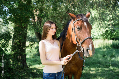 pretty brunette young woman with a white horse 
