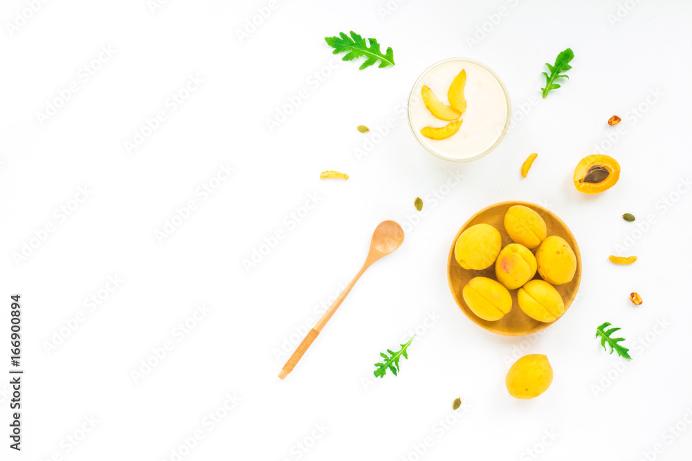 Healthy breakfast with fresh fruit, apricot, nuts, arugula, grapefruit, granola, cherry on white background. Flat lay, top view Healthy breakfast with fresh fruit, apricot, nuts, arugula, grapefruit, granola, cherry on white background. Flat lay, top view