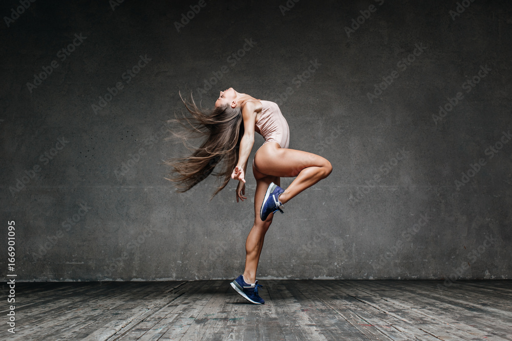 Young beautiful dancer is posing in studio