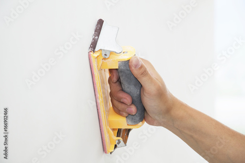 hand grinding wall with sandpaper