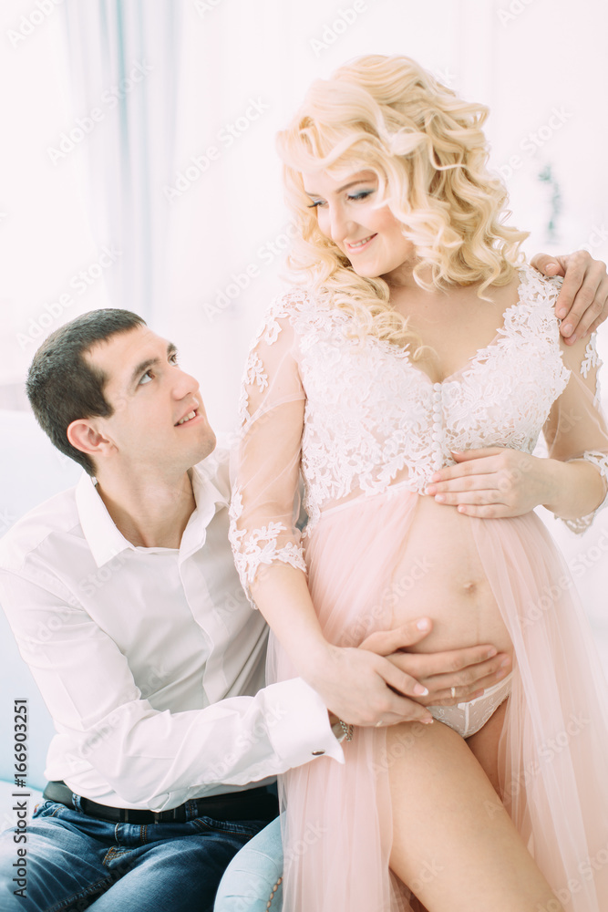 Pregnant young girl in a light orange dress with her husband Pregnant young girl in a light orange dress with her husband